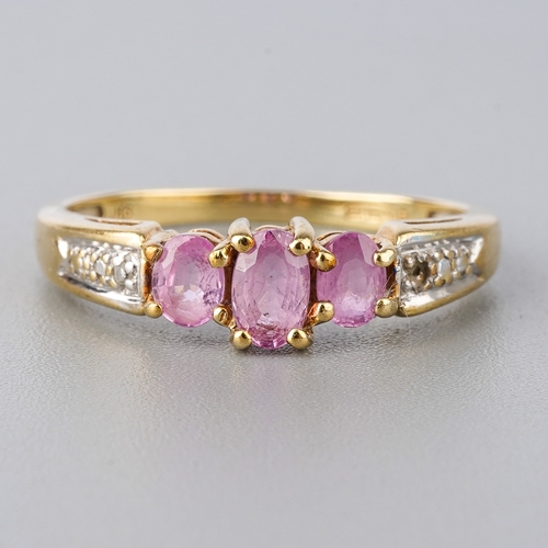 50 - A 9ct yellow gold pink sapphire ring, three oval mixed-cut sapphires, diamond chips to shoulders, si... 