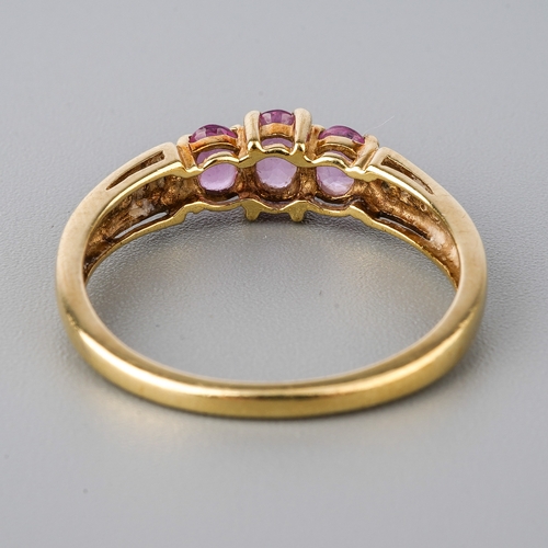 50 - A 9ct yellow gold pink sapphire ring, three oval mixed-cut sapphires, diamond chips to shoulders, si... 