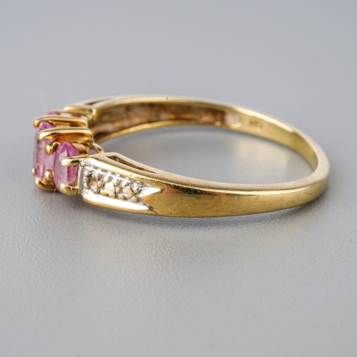 50 - A 9ct yellow gold pink sapphire ring, three oval mixed-cut sapphires, diamond chips to shoulders, si... 