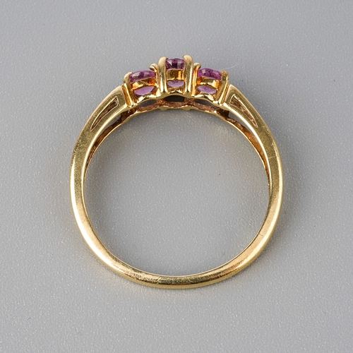 50 - A 9ct yellow gold pink sapphire ring, three oval mixed-cut sapphires, diamond chips to shoulders, si... 