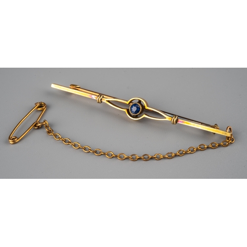 60 - An Edwardian 15ct yellow gold and sapphire bar brooch, set with a round cut sapphire, the clasp stam... 