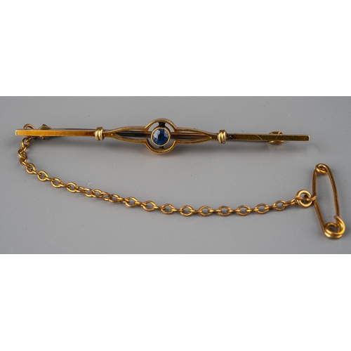 60 - An Edwardian 15ct yellow gold and sapphire bar brooch, set with a round cut sapphire, the clasp stam... 