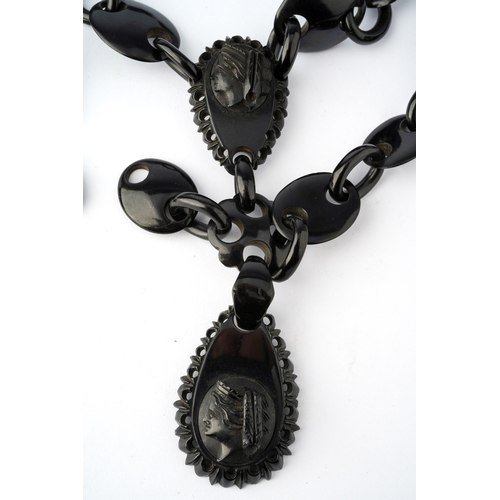 63 - A Victorian jet necklace, having two carved panels depicting the profile of classical ladies, suspen... 