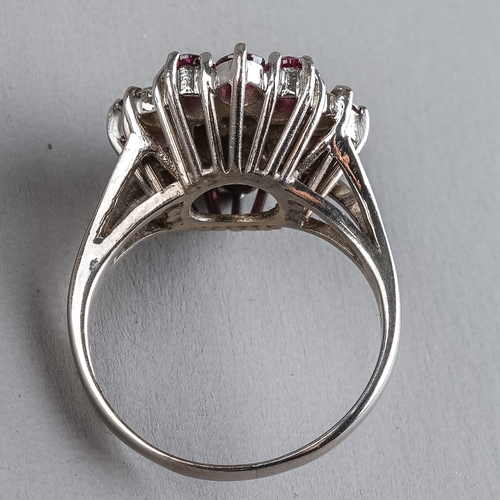 79 - An 18ct white gold diamond and ruby cluster ring, set with eleven round brilliant-cut diamonds and e... 