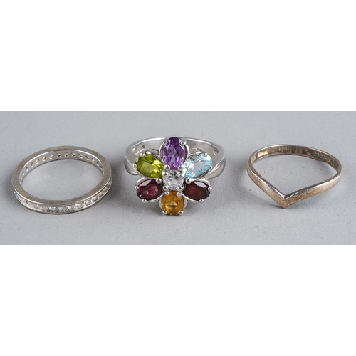 80 - Three silver rings, including a multi-gem set ring size N1/2; an eternity ring size M; and a wishbon... 