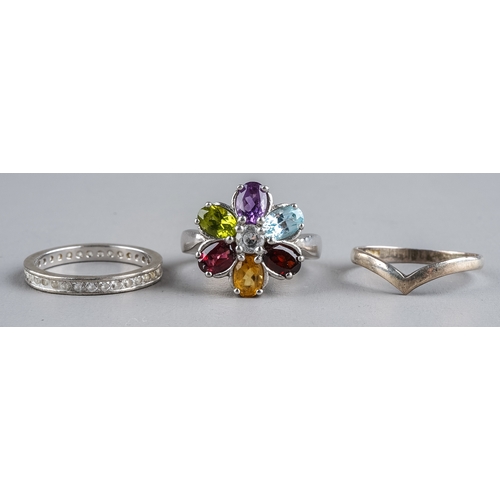 80 - Three silver rings, including a multi-gem set ring size N1/2; an eternity ring size M; and a wishbon... 