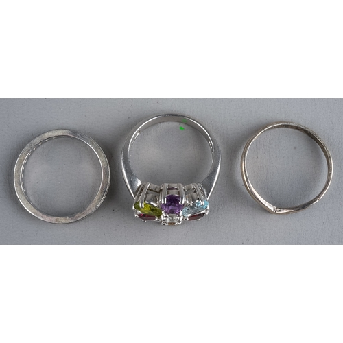 80 - Three silver rings, including a multi-gem set ring size N1/2; an eternity ring size M; and a wishbon... 