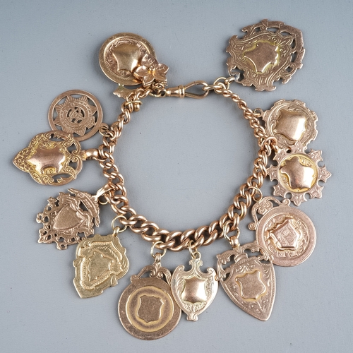 82 - A 9ct rose gold graduated curb link bracelet, suspending twelve 9ct gold fobs/medallions (all blank)... 