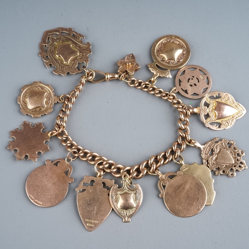 82 - A 9ct rose gold graduated curb link bracelet, suspending twelve 9ct gold fobs/medallions (all blank)... 