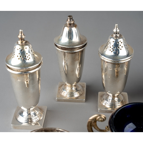 128 - A set of three silver open salts and a mustard pot and cover, Chester 1904, three with blue glass li... 