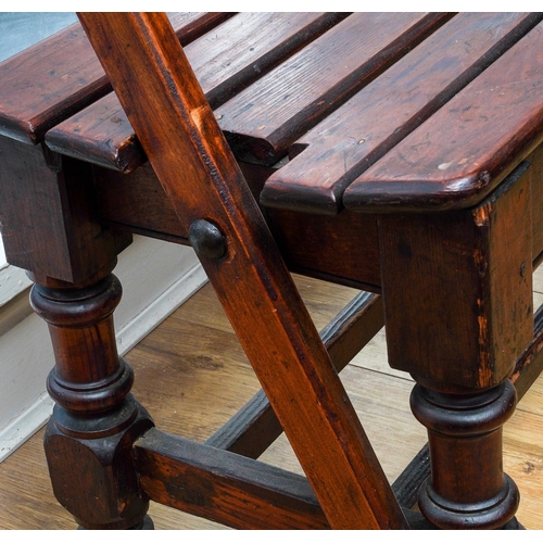 171 - An early 20th Century slatted wood tram bench with reversible back rest, on turned supports, 150cm l... 