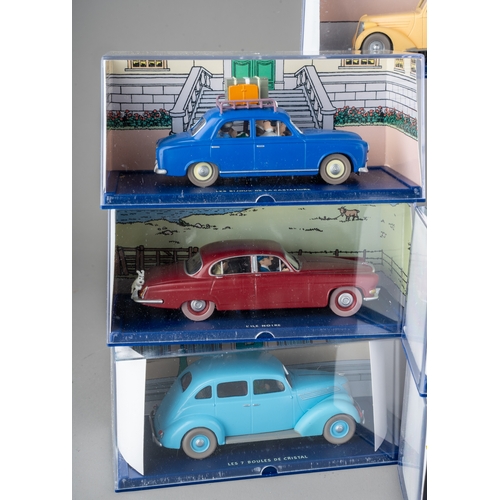 239 - A collection of Tintin Herge Moulinsart die cast models, all in perspex case with background design ... 