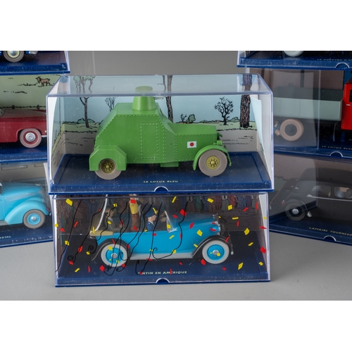 239 - A collection of Tintin Herge Moulinsart die cast models, all in perspex case with background design ... 