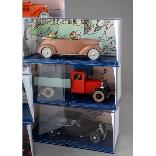 239 - A collection of Tintin Herge Moulinsart die cast models, all in perspex case with background design ... 