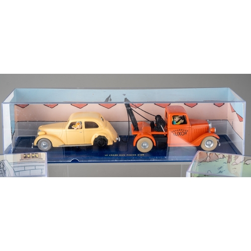 239 - A collection of Tintin Herge Moulinsart die cast models, all in perspex case with background design ... 