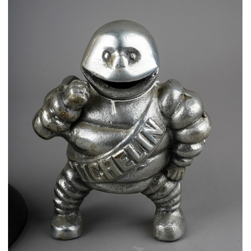 278 - A cast metal model of a revolving Michelin man, with yellow sash, approx 30cm high and a chrome mode... 