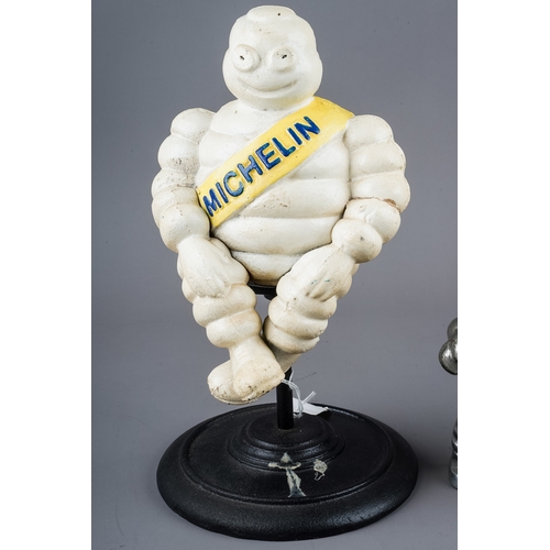 278 - A cast metal model of a revolving Michelin man, with yellow sash, approx 30cm high and a chrome mode... 