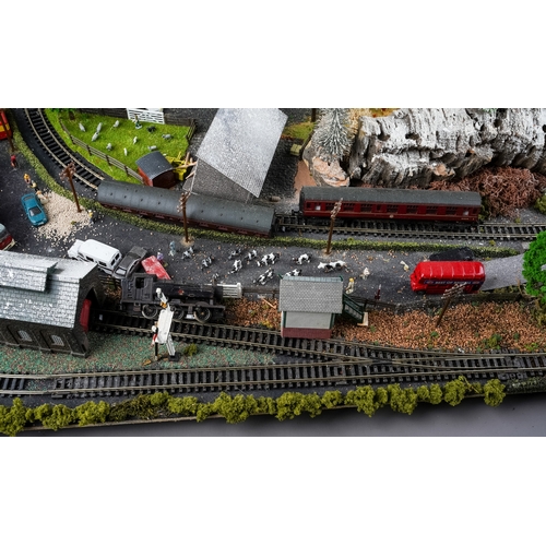 299 - A model railway N gauge train layout fixed on board, the diorama features wintery village scene with... 