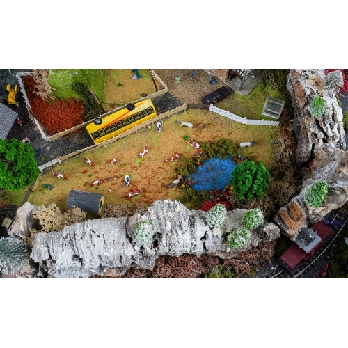 299 - A model railway N gauge train layout fixed on board, the diorama features wintery village scene with... 