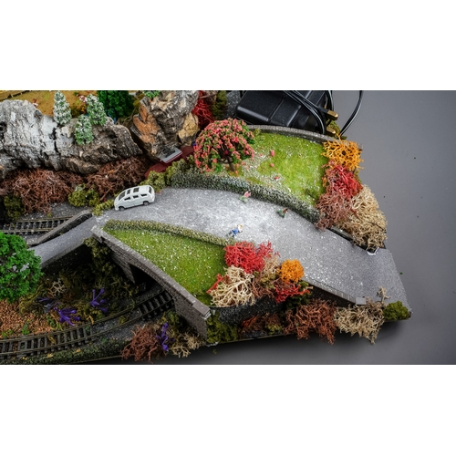 299 - A model railway N gauge train layout fixed on board, the diorama features wintery village scene with... 