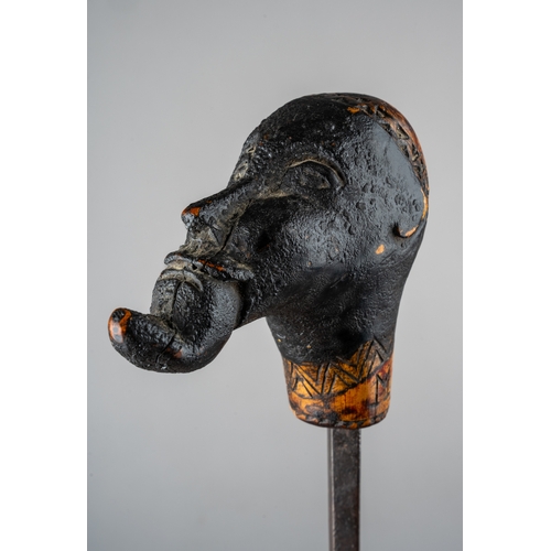 344 - An unusual tribal carved sword stick, in the form of a man with something in his mouth, incised carv... 