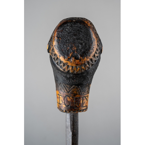 344 - An unusual tribal carved sword stick, in the form of a man with something in his mouth, incised carv... 