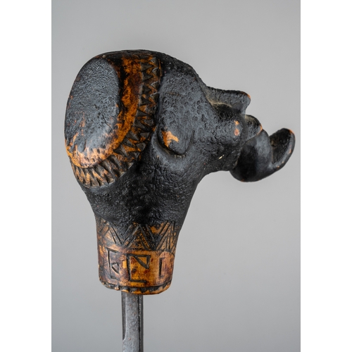 344 - An unusual tribal carved sword stick, in the form of a man with something in his mouth, incised carv... 