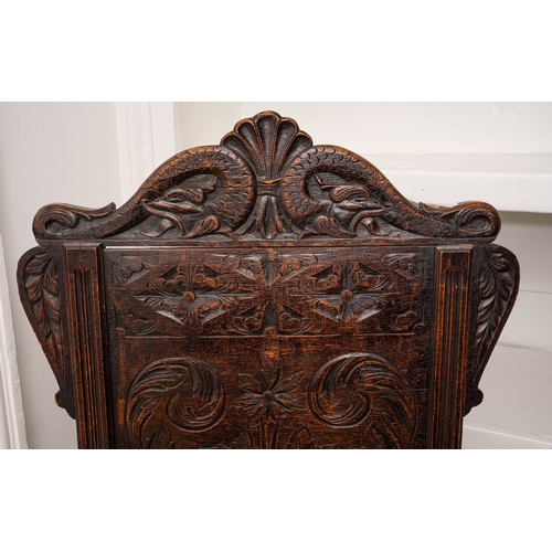 366 - A Victorian oak Wainscot chair, carved arched back, scrolled arms, boarded seat, turned legs and rai... 