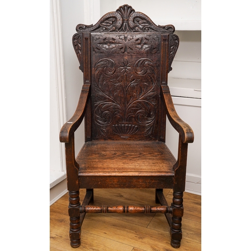 366 - A Victorian oak Wainscot chair, carved arched back, scrolled arms, boarded seat, turned legs and rai... 