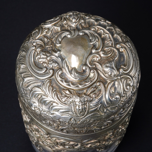 546 - A Victorian silver mounted cylindrical scent bottle, the hinged domed cover embossed with foliate sc... 