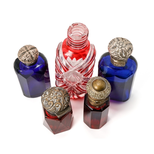 547 - A collection of five red and blue glass scent bottles, two with silver lids, two with base metal lid... 