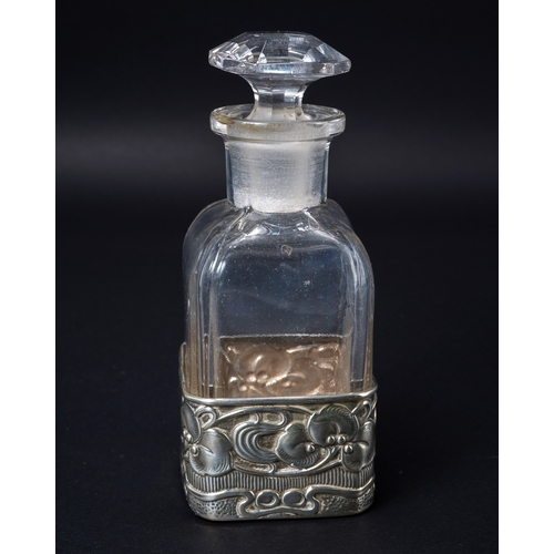 553 - An Art Nouveau silver and glass scent bottle, the silver sleeve embossed with leaves and berries wit... 