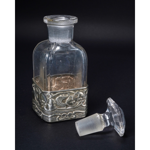 553 - An Art Nouveau silver and glass scent bottle, the silver sleeve embossed with leaves and berries wit... 