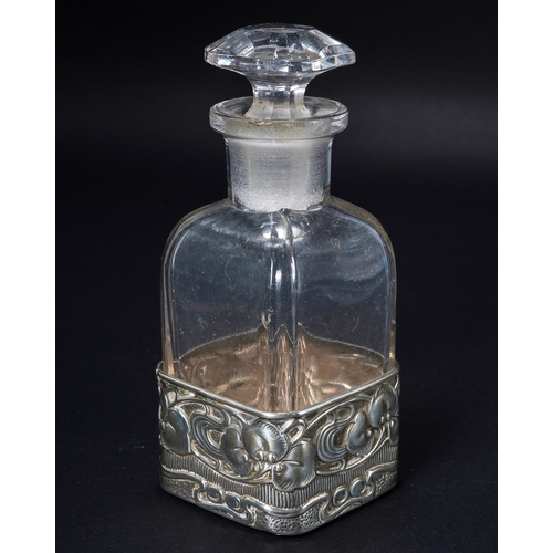 553 - An Art Nouveau silver and glass scent bottle, the silver sleeve embossed with leaves and berries wit... 