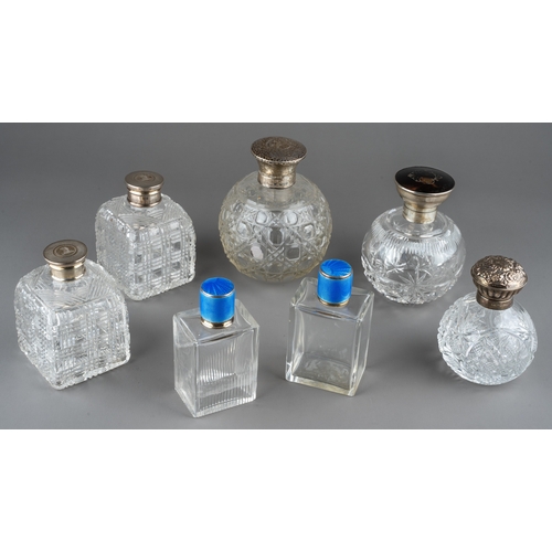 567 - A collection of seven silver mounted cut glass scent bottles, including a matched pair of Art Deco r... 