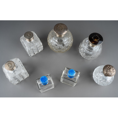 567 - A collection of seven silver mounted cut glass scent bottles, including a matched pair of Art Deco r... 