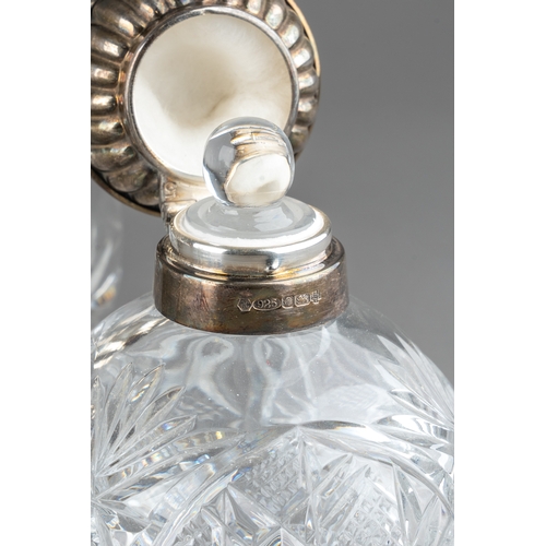 567 - A collection of seven silver mounted cut glass scent bottles, including a matched pair of Art Deco r... 