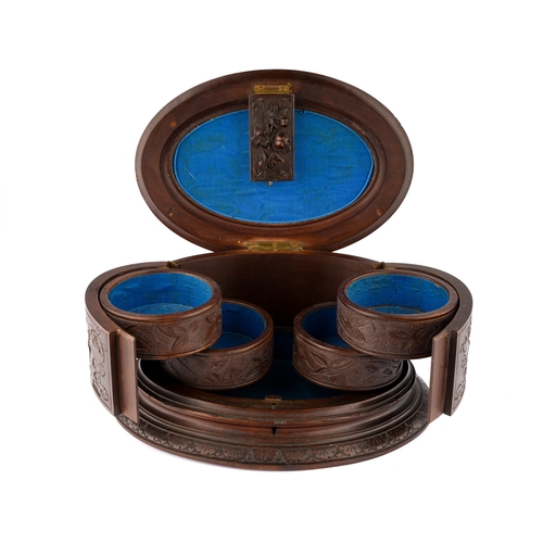 586 - A Black Forest jewellery / games box, circa 1900/1910, oval body with hinged cover surmounted by a p... 