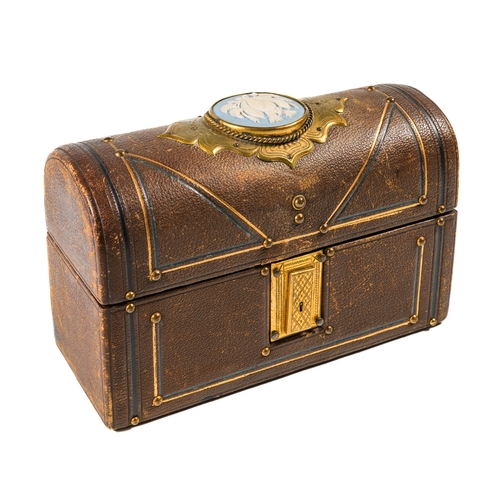 595 - A Victorian leather domed casket, applied with brass fittings, the top inlaid with a Jasper ware cam... 