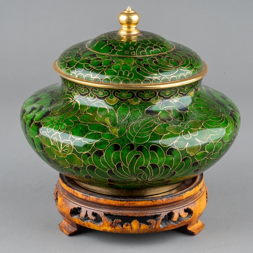 632 - A Chinese green Cloisonné pot and cover, with lotus flower decoration, on carved stand, the pot appr... 