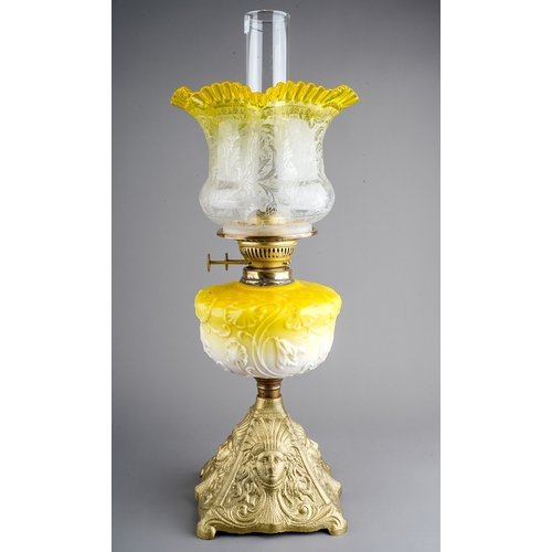 638 - A Victorian style gilt metal oil lamp, the yellow resevoir moulded with scrolling flowers, with etch... 