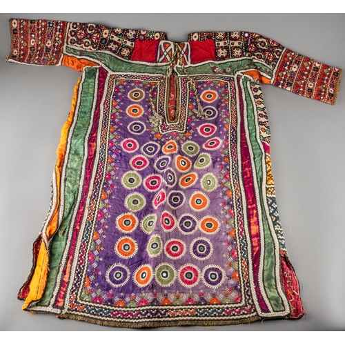 661 - A vintage Uzbek vari-colour profusely embroidered and embellished tunic probably wedding tunic, the ... 