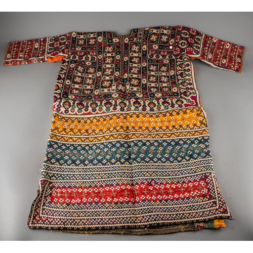 661 - A vintage Uzbek vari-colour profusely embroidered and embellished tunic probably wedding tunic, the ... 