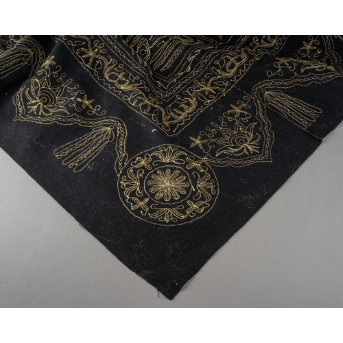 665 - An Asian long black panel embroidered with flowers and foliage in gold and silver threads with tassl... 