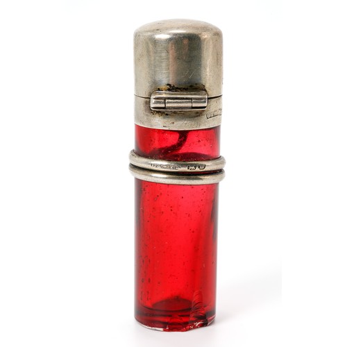 566 - A Victorian silver mounted cranberry glass scent bottle, the cylindrical glass base applied with a c... 