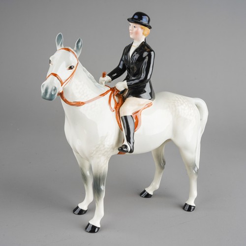 434 - A Beswick model of a Huntswoman on a dapple horse, she wears black jacket and bowler, stamped unders... 