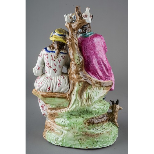 436 - A Staffordshire figural group modelled as a seated Gentleman piping with Lady listening, the tree st... 