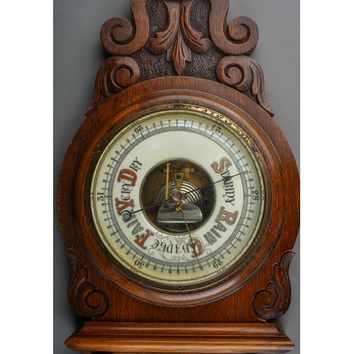 688 - A Victorian oak framed aneroid barometer, the carved case with pediment above column supports, the l... 