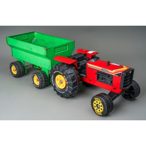 38 - Tonka Toys. A red farm tractor missing steering wheel with accompanying green trailer.  Large scale ... 