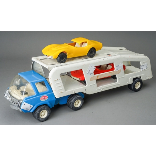 90 - Tonka Toys.  A medium scale articulated car transporter, blue cab, white body, with 2 plastic cars (... 